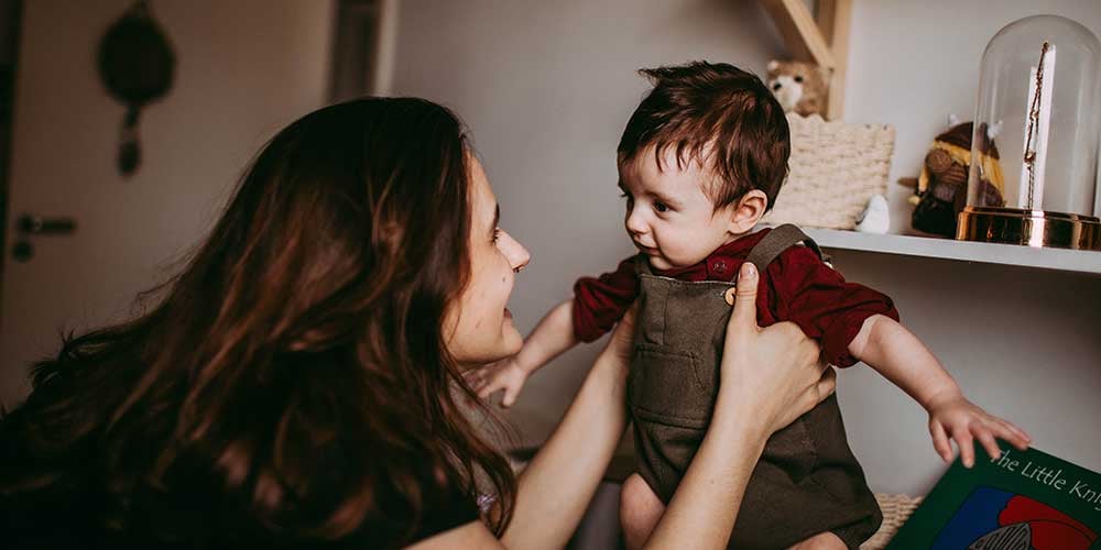 mum holding up baby