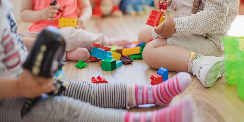 children playing with wooden toys on the floor