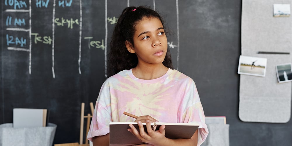 girl with notebook thinking about investing