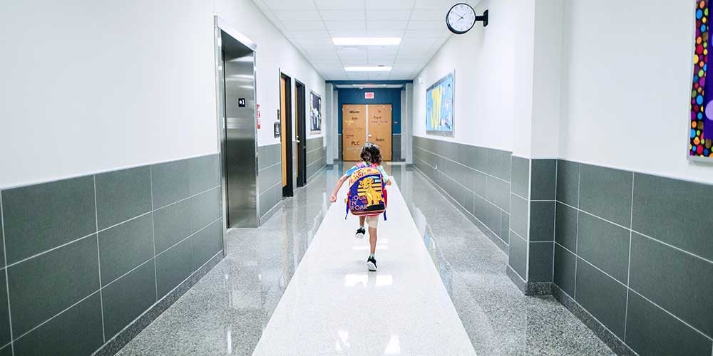 child running in school hallway 