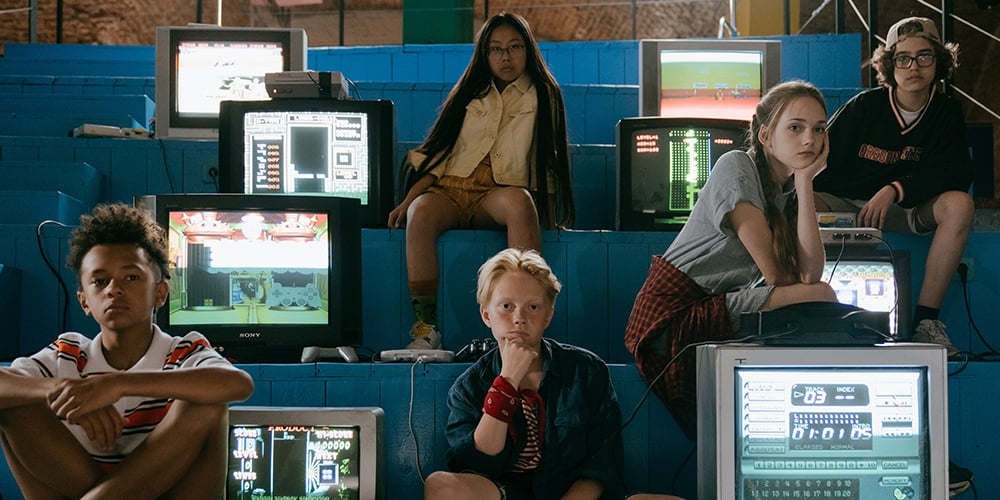 children sitting next to tvs