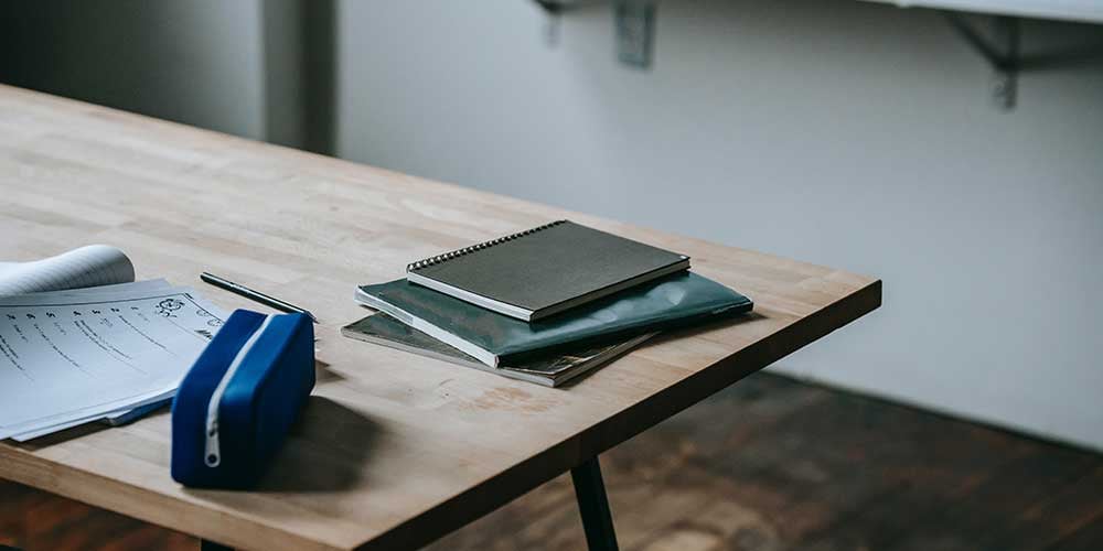 pencil case and notebooks on a desk