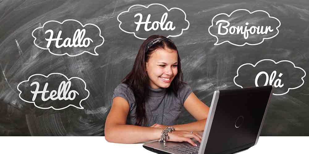 girl using a laptop with blackboard behind