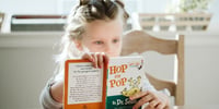 little girl decoding a book