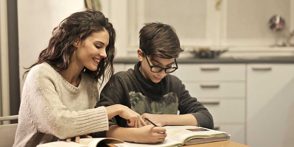 mother and child studying at table preparing for exams