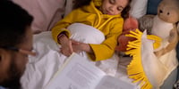 kids reading a book in bed
