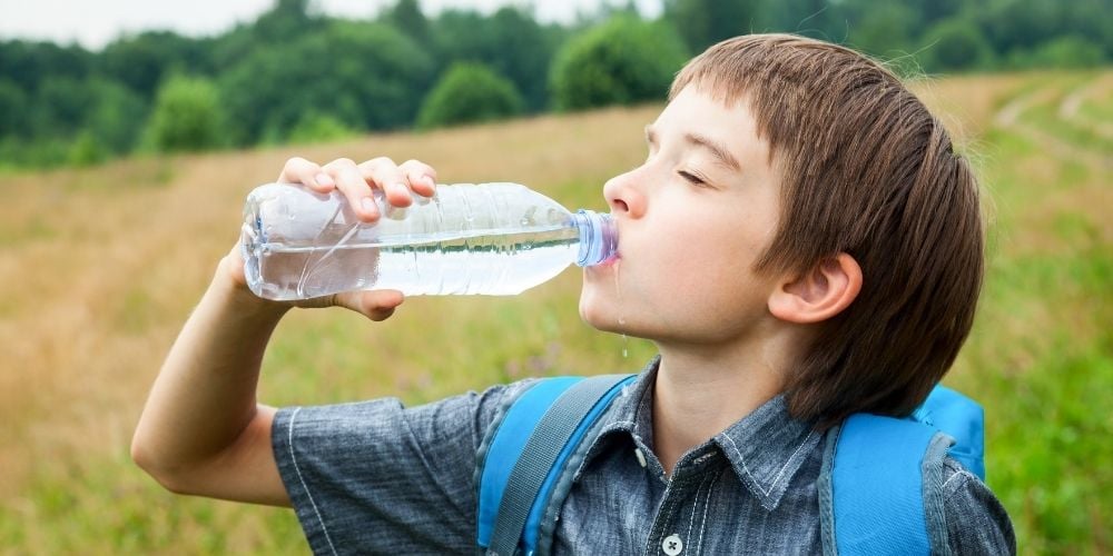 importancia-de-beber-agua-nino-bebiendo-botella-agua