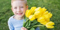 nino-con-flores-de-primavera-tulipanes-amarillos