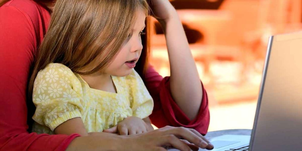 girl on computer with parent