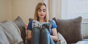 Girl reading book on sofa