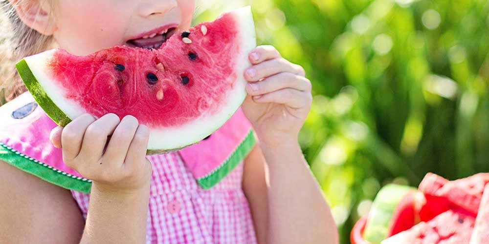 child eating a watermelon
