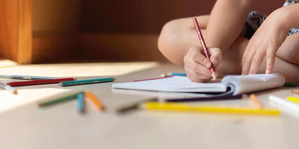 child writing in school book