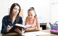 Girl reading with teacher