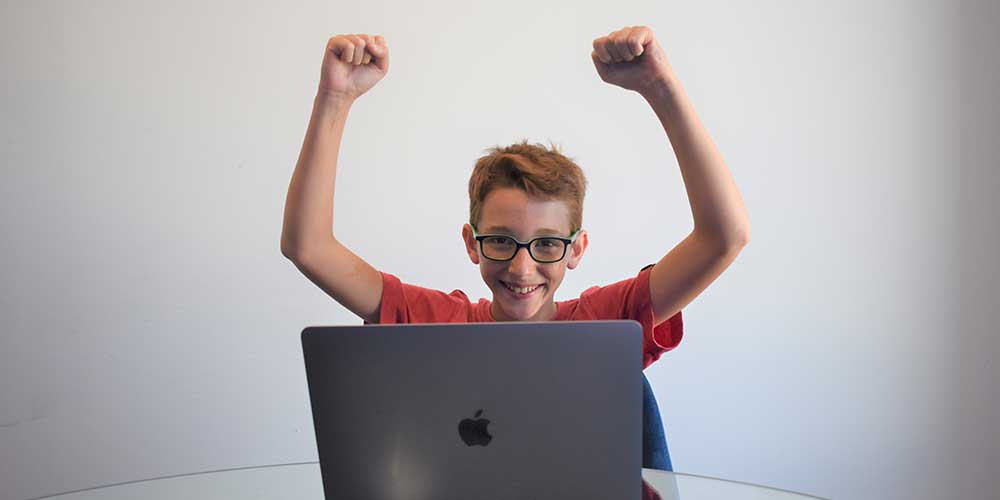 boy looking happy while learning to code