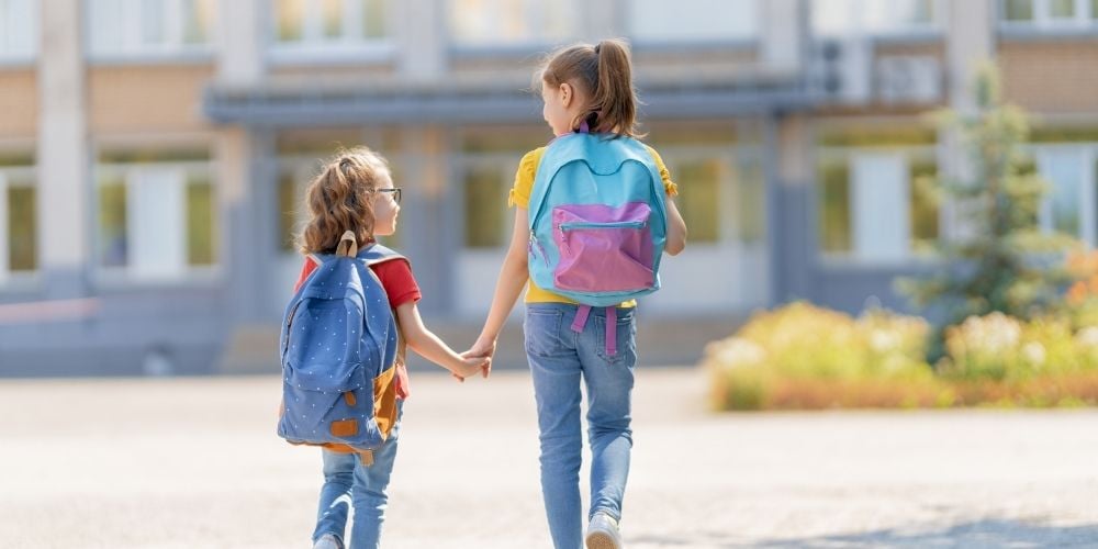 absentismo-escolar-ninas-yendo-al-colegio-mochilas